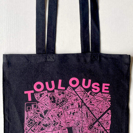 Black tote bag with map of Toulouse printed on the front in pink color